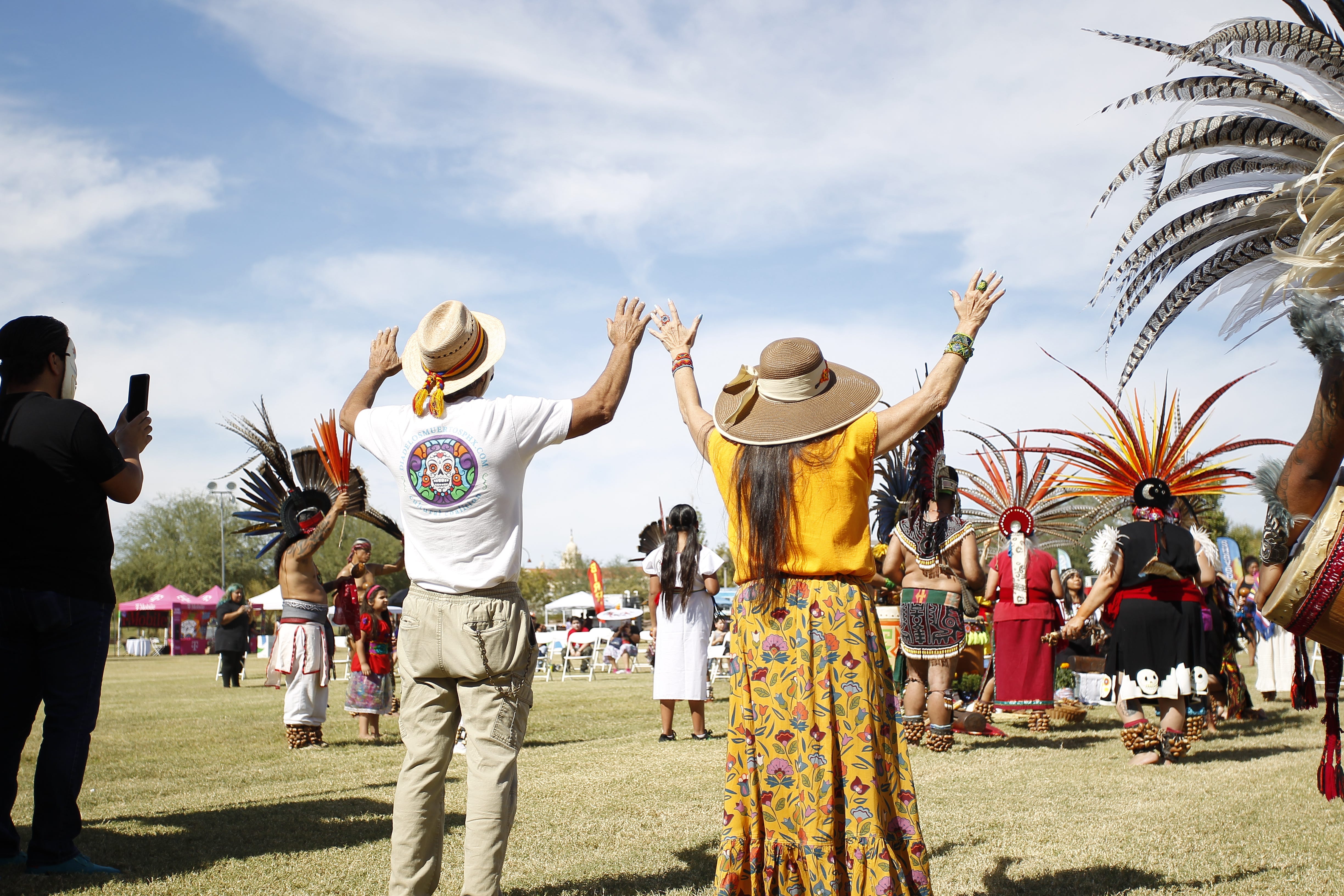 Zarco (left) and Carmen (right) Guerrero raise their arms during Yolloincuauhtil Aztec Dancers' ceremonial blessing on Oct. 24, 2021, in Phoenix.