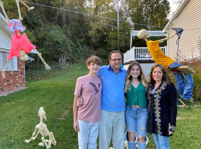 The Wilkes family poses with their skeletons on Oct. 25. They've made different sceneries for the skeletons every day of October.