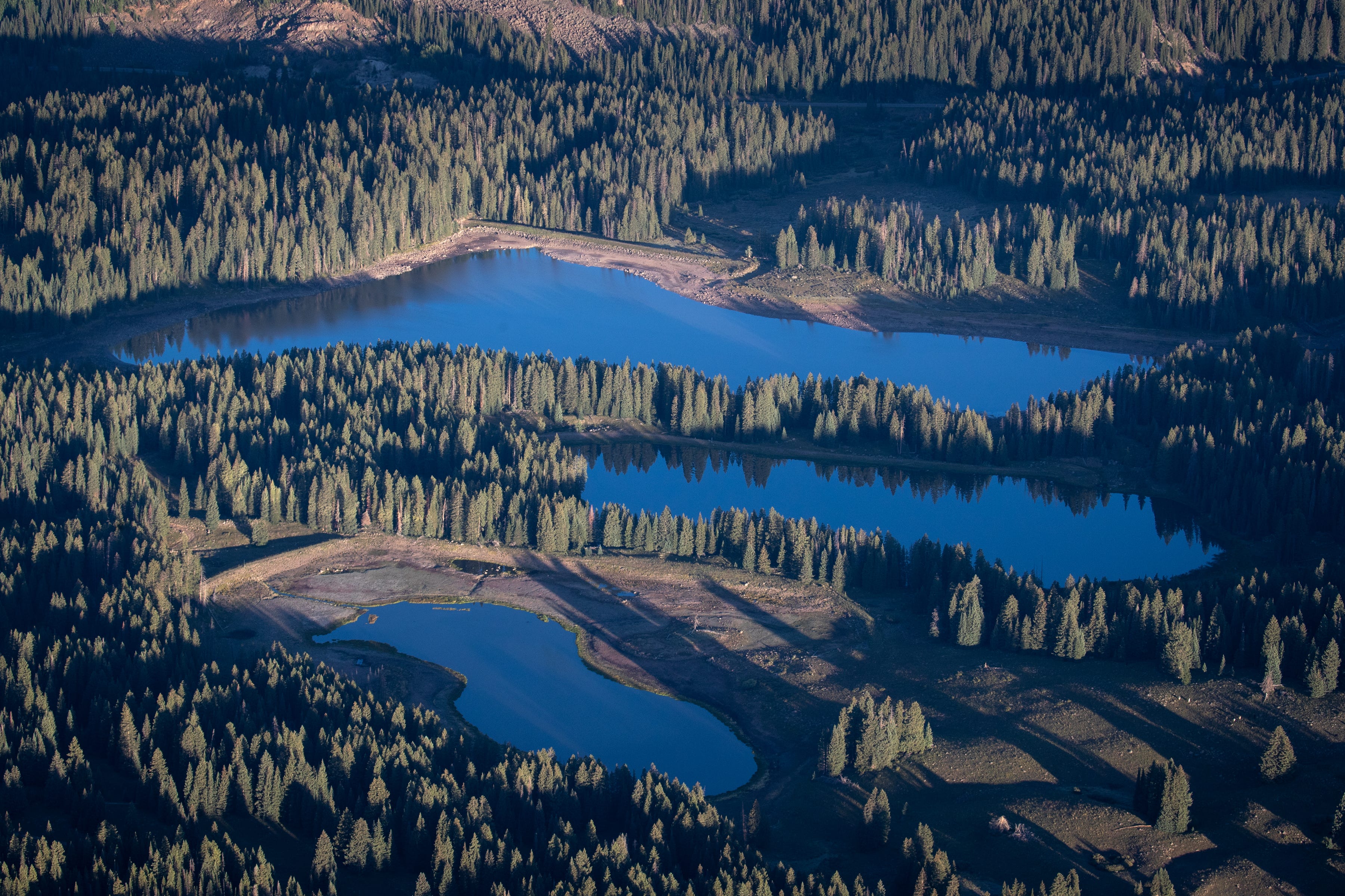 A few of the many reservoirs in the Grand Mesa National Forest. While the lakes hold back snowmelt, almost none of it flows naturally to the river system below. The Forest Service allows these structures to withhold water for irrigation systems downstream. Aerial photography support provided by LightHawk.