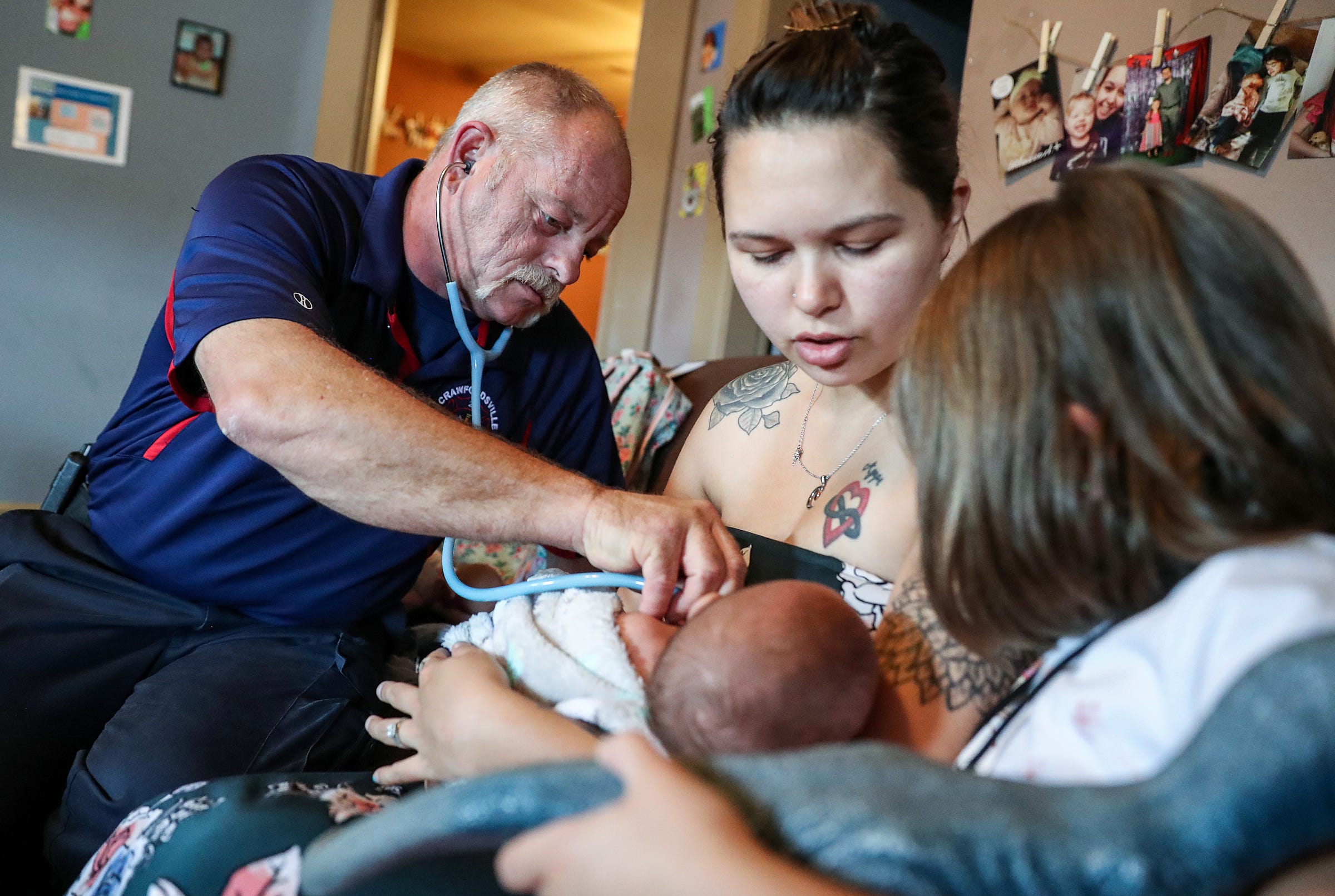 Project Swaddle community paramedic Darren Forman (left) checks 7-month-old Easton Mings, held by his mother Chloe Mings on Wednesday, Aug. 7, 2019