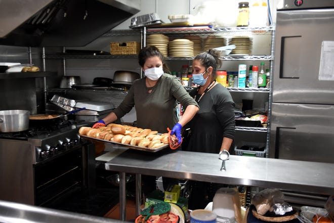 Spirit of Santa Paula homeless shelter residents and volunteers Laura Iteriano (left) and Maria Sanchez prepare to serve lunch in October.