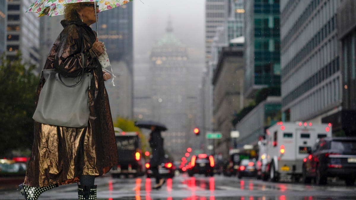 Pedestrians make their way through a rainy and foggy New York, Tuesday, Oct. 26, 2021.