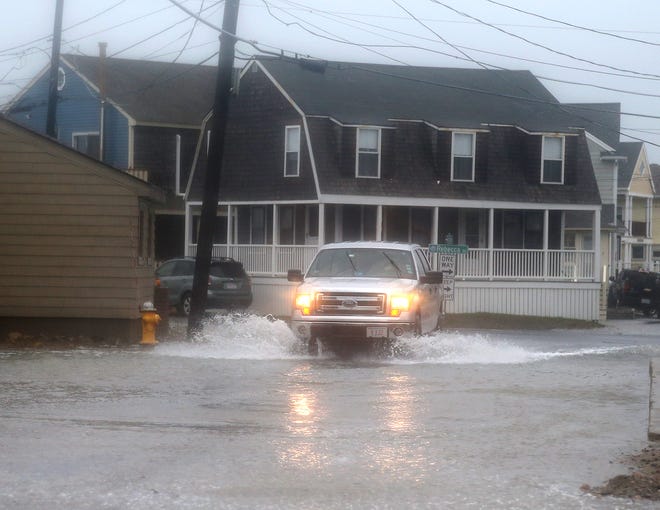 A pickup truck was awakened during high tide flooding in Scituate, Mass., in October 2021. National Oceanic Administration officials say such flooding is occurring at least twice as often. occurred frequently in the year 2000.
