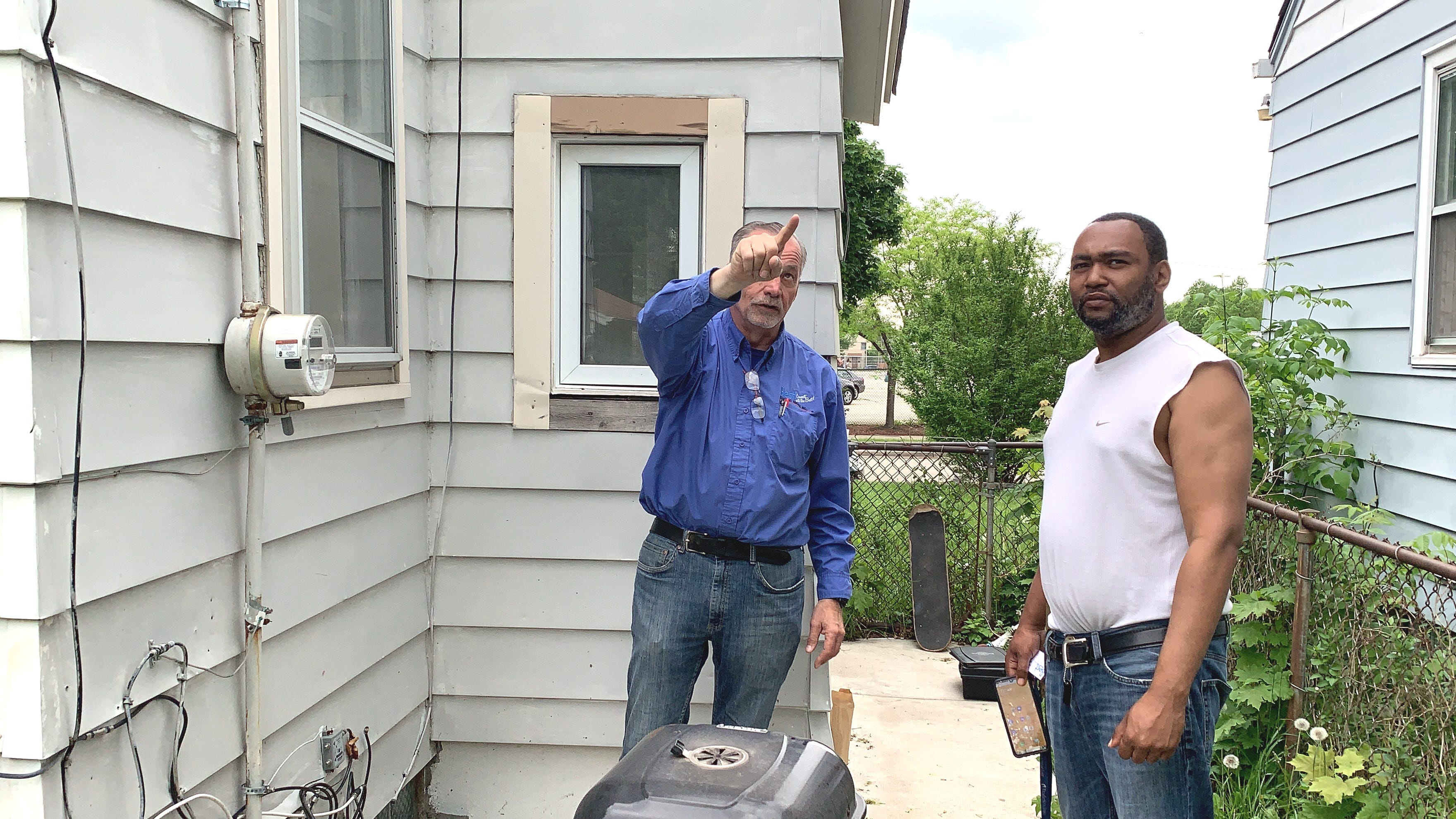 In May 2021, electrician Bruce Janczak talks with renter Tirrell Glosson about an issue with the overhead wiring outside the home Glosson and his fiancee rent on West Thurston Avenue.