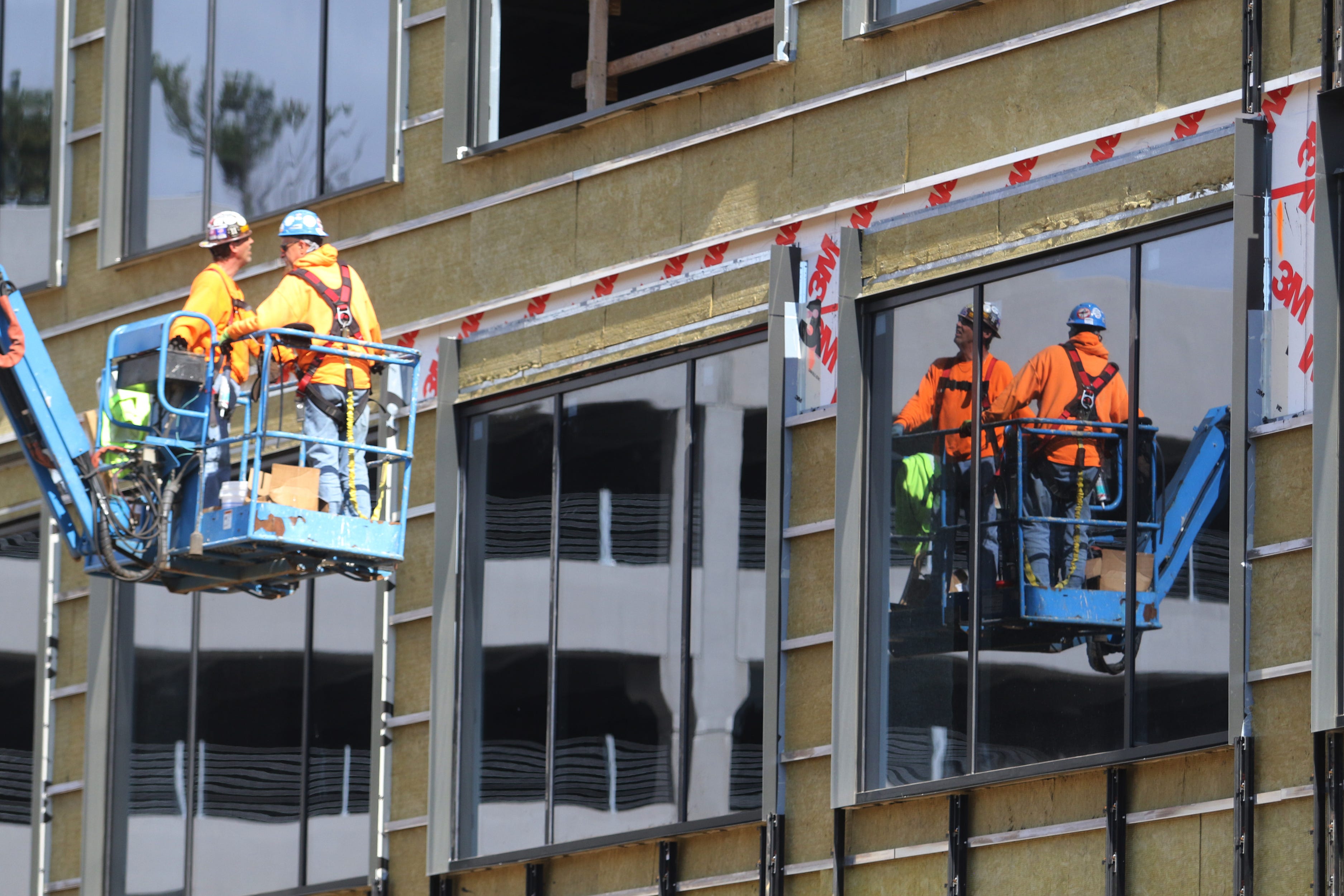 Workers inspect newly installed windows on the face of the new Deloitte office building on Morris Street in Morristown on October 8, 2021.