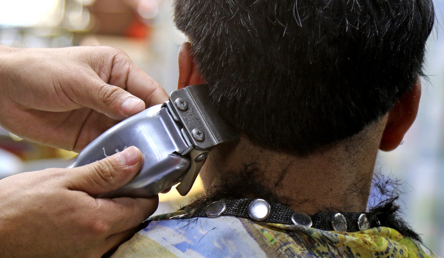 A barber uses a hair trimmer on a customer at La Peluqueria Barber Shop on Speedwell Avenue on October 14, 2021.