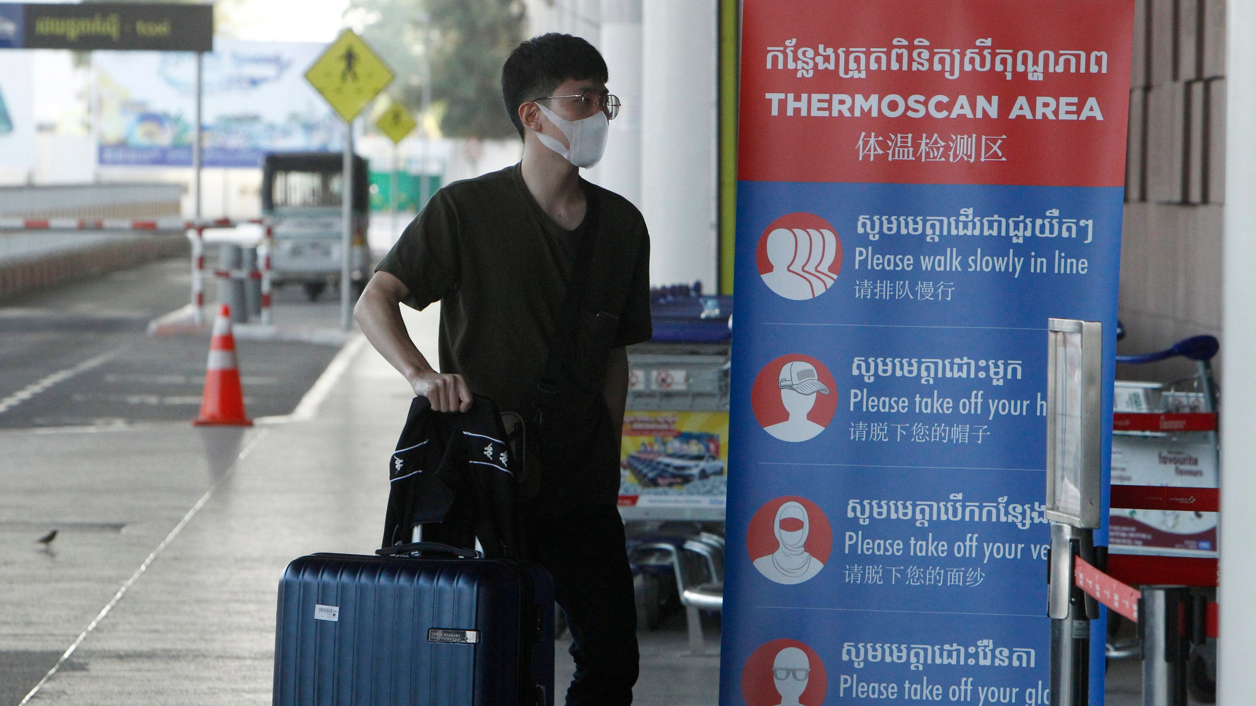 A tourist wearing a face mask enters an area of thermo scan at Phnom Penh International Airport in this file photo from April 3, 2020.