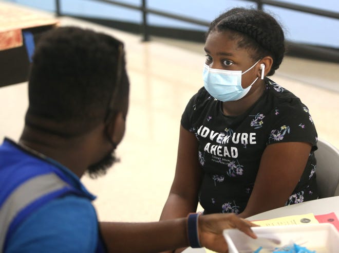 Monica Brandon, 12, gets ready to receive her first dose of a COVID-19 vaccine during a clinic at the Shawnee Arts & Cultural Center in Louisville's West End on Oct. 14, 2021.