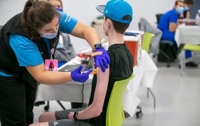 Nurse Erin Morgan administers the Pfizer COVID-19 vaccine to 14-year-old Zach Bilyj, of Wake Forest, N.C., during a vaccination clinic at the Wake County Human Services clinic on Departure Drive, in Raleigh, N.C.