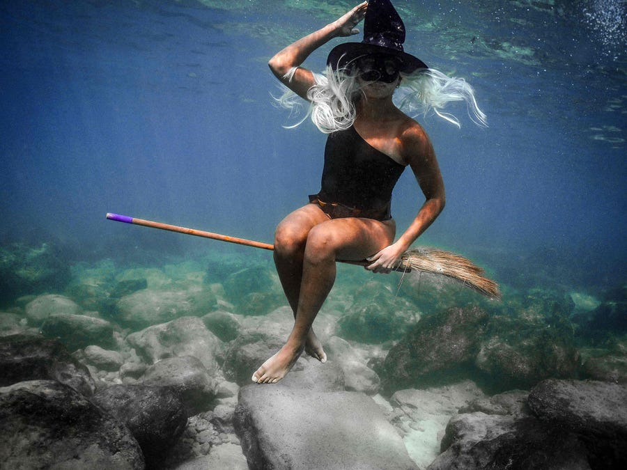 October 28, 2021:  A woman dressed in a Halloween costume swims along the coast of the northern Lebanese city of Batroun.