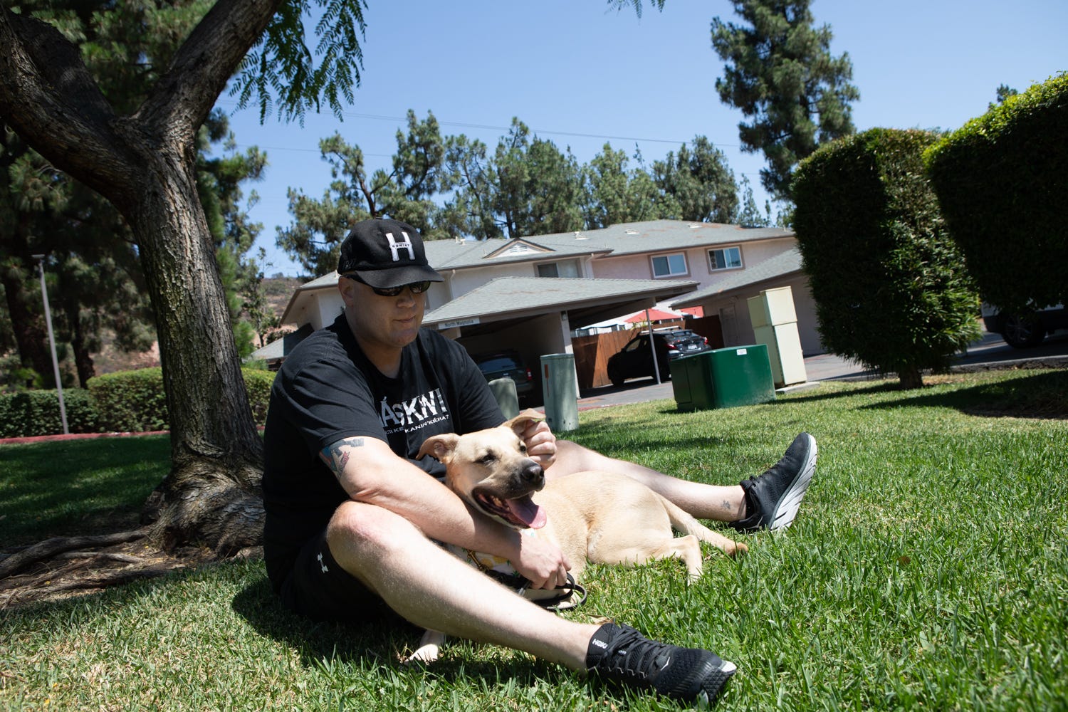 Kiowa Wolfe sits with his dog, Marlow, outside of his home in Santee, Aug. 5, 2021.