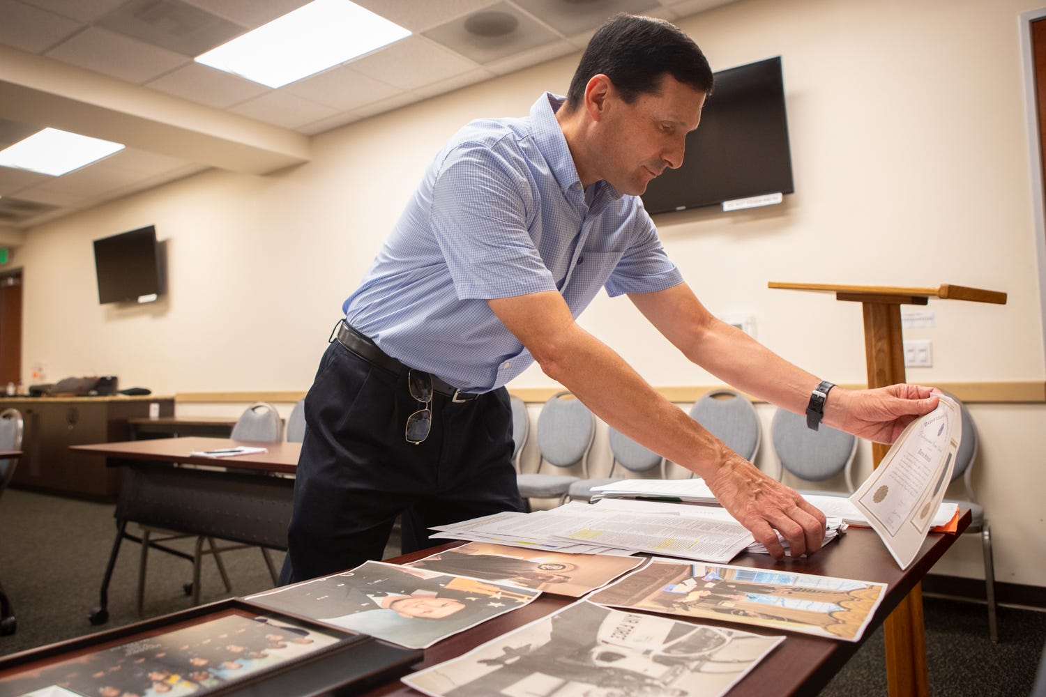 Darin Selnick looks through photos and documents from his time working on the Mission Act at the Veterans Association of North County, Aug. 10, 2021.