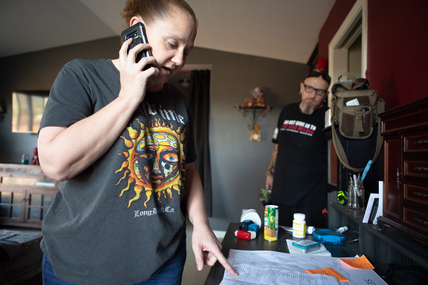 Amy Warix stands at the desk where she makes calls to advocate for her partner John's healthcare, Warner Springs, Calif., Sept. 30, 2021.