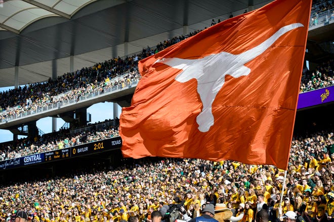 A fan waves a Longhorn flag during the 2015 Texas-Baylor game at McLane Stadium in Waco. The two schools have played each other 110 times.