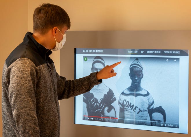 Andrew Donovan looks at a digital display about his great-great grandfather and champion cyclist, Marshall W. “Major” Taylor, inside the new Major Taylor Museum on Friday in Worcester. Taylor is seen in a photograph with members of his cycling team in 1897, and is one of the earliest photographs of an integrated professional sports team.