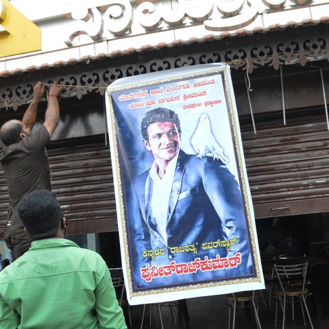 A poster of actor Puneeth Rajkumar is hung outside