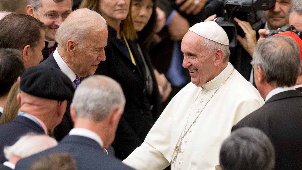 FILE - In this April 29, 2016, file photo Pope Francis shakes hands with Vice President Joe Biden as he takes part in a congress on the progress of regenerative medicine and its cultural impact, being held in the Pope Paul VI hall at the Vatican.
