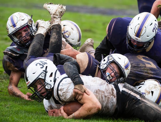 South Side running back Cam Knox (34) gets stopped by a pile of muddy Western Beaver defenders Saturday at Rich Niedbala Field. [Lucy Schaly/For BCT]