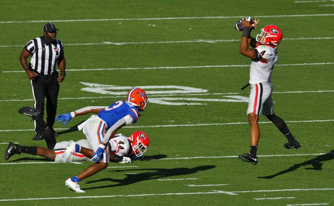 Georgia linebacker Nolan Smith intercepts a pass that was tipped by teammate Travon Walker during the second quarter of Saturday's game against Florida at TIAA Bank Field.