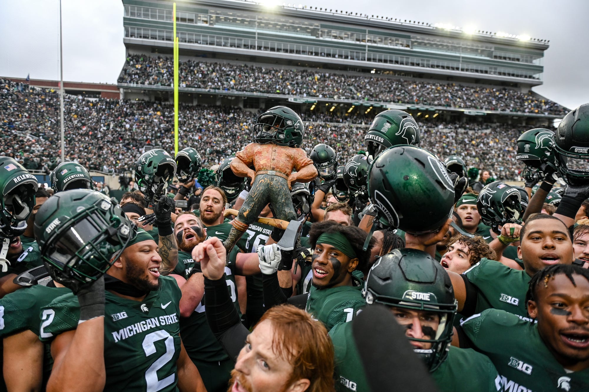Michigan State celebrates with Paul Bunyan trophy after beating in-state rival Michigan 37 - 33