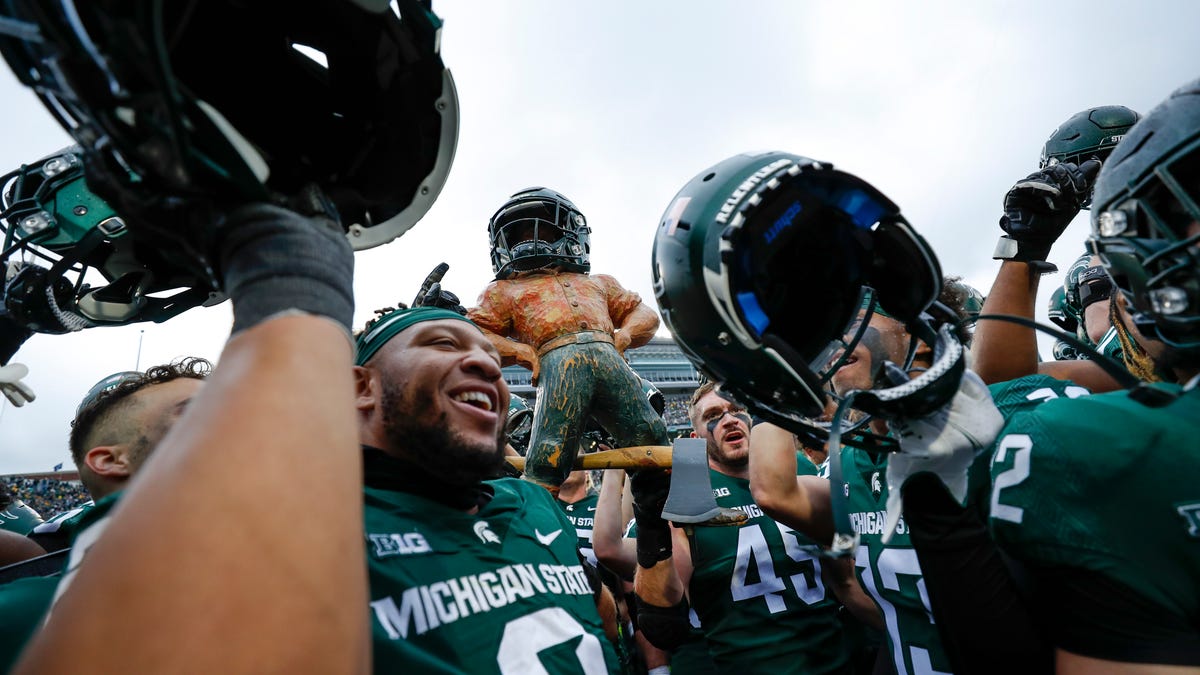 The Michigan State Spartans hold up the Paul Bunyan trophy in celebration after the game against Michigan at Spartan Stadium.