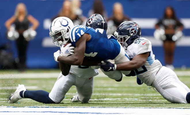 Indianapolis Colts wide receiver Zach Pascal (14) is brought down by defenders including Tennessee Titans linebacker Monty Rice (56) on Sunday, Oct. 31, 2021, during a game against the Tennessee Titans at Lucas Oil Stadium in Indianapolis.