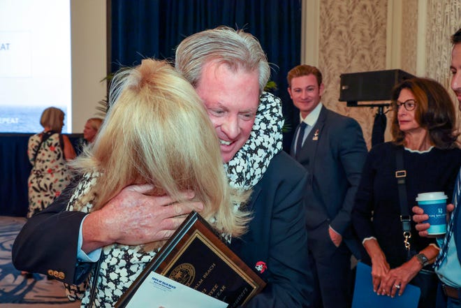 Tony Chateauvert, head professional at the Par 3, receives a congratulatory hug after being named the Town of Palm Beach Employee of the Year Monday at the Palm Beach Chamber of Commerce monthly breakfast.
