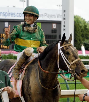 Jockey Miguel Mena celebrates after guiding Pool Play to win the Stephen Foster Handicap horse race at Churchill Downs in Louisville, Ky., Saturday, June 18, 2011. (AP Photo/Garry Jones)