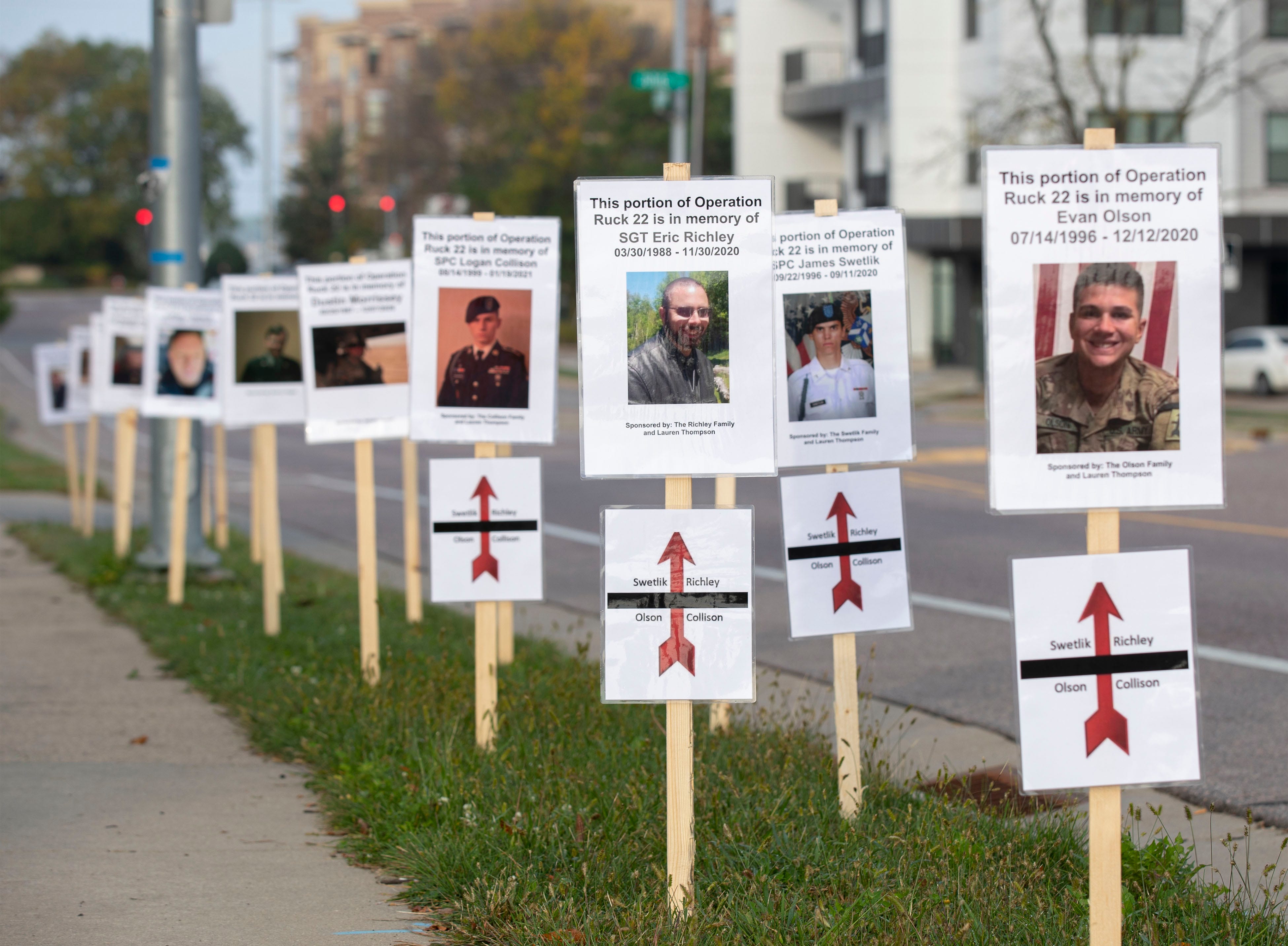 Signs honoring veterans who have died by suicide are displayed along the path of a memorial march in October in Madison.