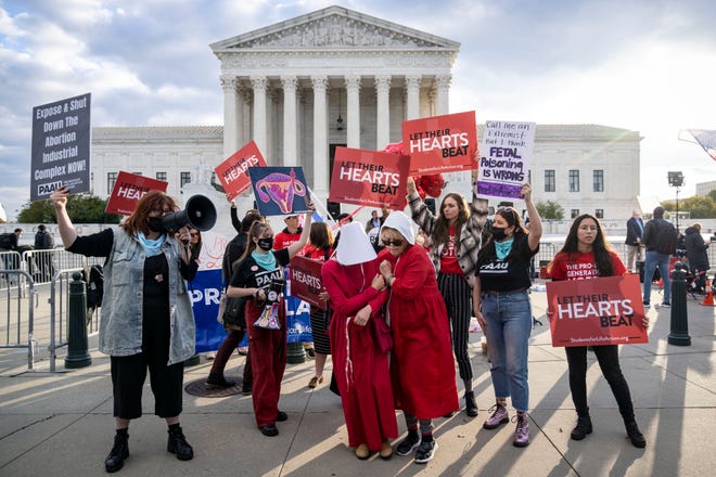 Two pro-choice demonstrators are surrounded by anti-abortion demonstrators outside the U.S. Supreme Court on Nov. 01, 2021 in Washington, DC. On Monday, the Supreme Court is hearing arguments in a challenge to the controversial Texas abortion law which bans abortions after 6 weeks.