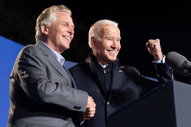 President Joe Biden, right, reacts after speaking at a rally for Democratic gubernatorial candidate, former Virginia Gov. Terry McAuliffe, Tuesday, Oct. 26, 2021, in Arlington, Va.