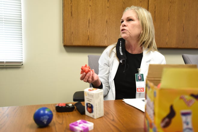 Jo Dalton, a pediatric nurse working at Hamilton County Public Health, shows toys and devices that will be used to help children feel safe and comfortable while they get the COVID-19 vaccine.