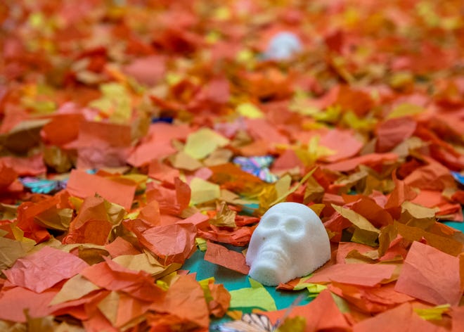 A sugar skulls rests on orange leaves made of paper for a Day of the Dead (Dia de los Muertos) altar at Fremont Elementary School in Salinas, Calif., on Tuesday, Nov. 2, 2021.