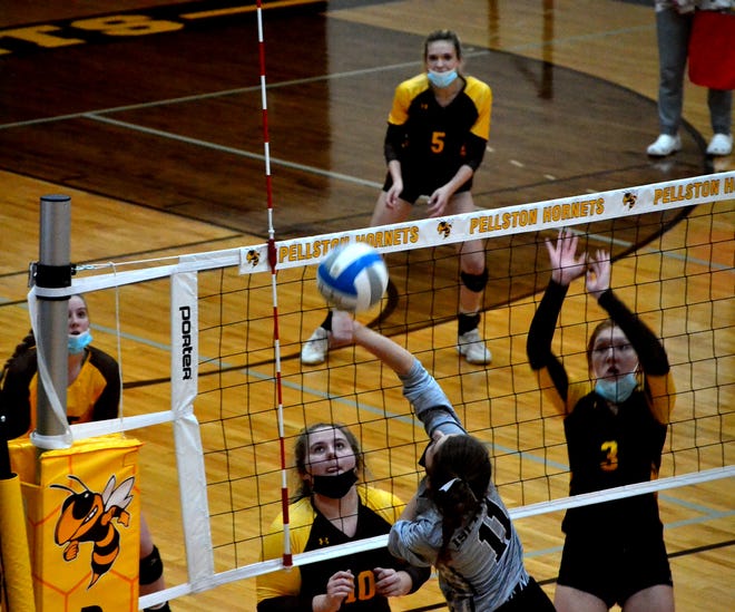 Pellston's Megan Bricker (10) and Lillie Bourrie (3) go up to block a kill attempt from Cedarville-DeTour's Ciara Solomonson (11) during a MHSAA Division 4 volleyball district semifinal in Pellston on Tuesday.