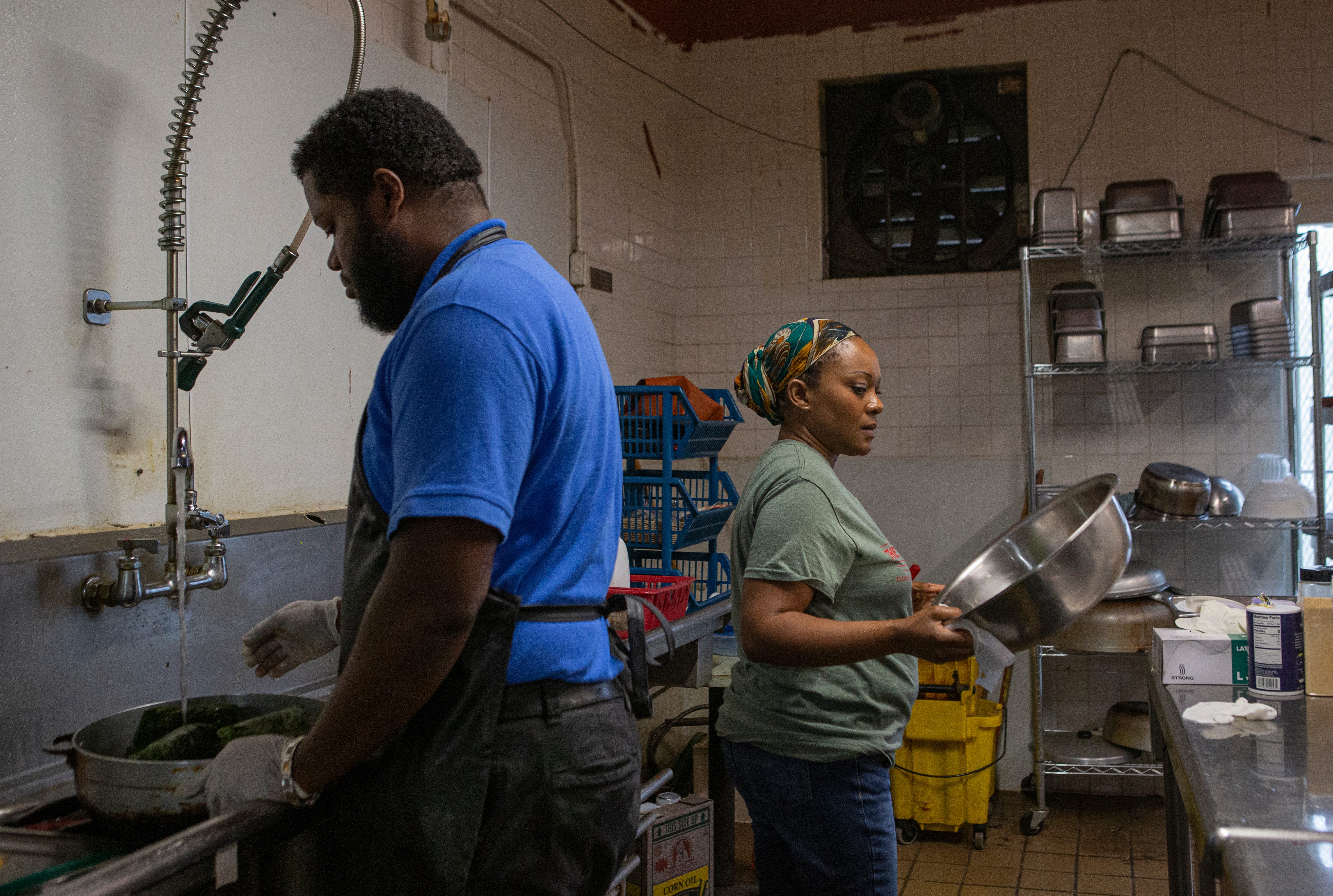 Ullys Mouity and his wife Adija Balume Mouity prep the dishes needed for the day in Syracuse, N.Y., on Oct. 30, 2021.