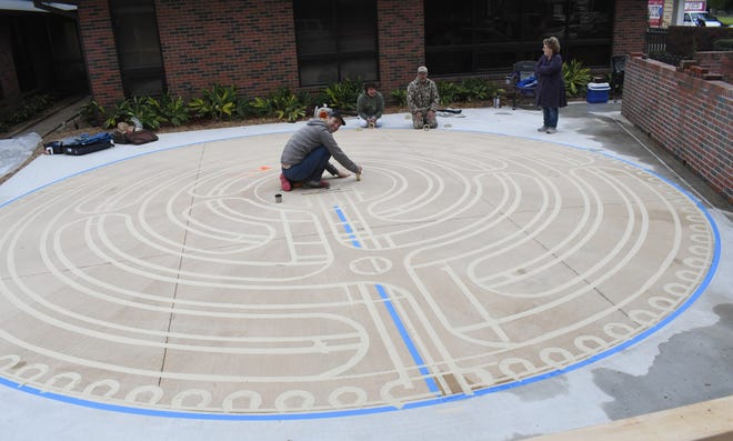 Lars Howlett (front left), a professional labyrinth designer and builder with Discover Labyrinths, is building a 7-circuit aligned labyrinth outside the Rapides Cancer Center at Rapides Regional Medical Center. Helping him are Bobby Ducote and David Hicks, both with RRMC. Annelle Brown Tanner (right) and her husband Martin Tanner approached RRMC about building a community labyrinth on their campus.