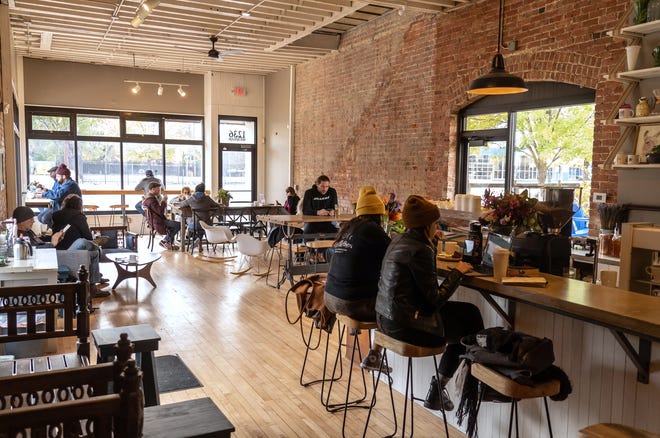 Customers hang out while eating and drinking at James Oliver Coffee Co. on Michigan Avenue in Detroit's Corktown neighborhood on November 4, 2021. The coffee shop now occupies the former Detroit Institute of Bagels building.