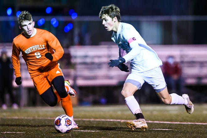 Okemos' Jack Guggemos, right, moves with the ball as Northville's Alex Nevelos follows along during the first half on Wednesday, Nov. 3, 2021, at Grand Ledge High School.