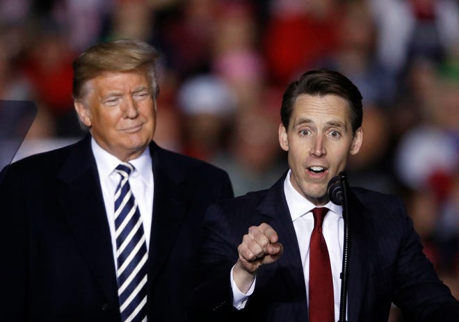 President Donald Trump listens as Republican Senate candidate Josh Hawley speaks during a campaign rally at Columbia Regional Airport, Thursday, Nov. 1, 2018, in Columbia, Mo. A federal lawsuit accuses the National Rifle Association of violating campaign finance laws by using shell companies to illegally funnel up to $35 million to Republican candidates, including former President Trump, Sen. Hawley of Missouri and others.