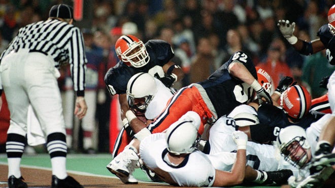 Penn State fullback Brian Milne, left, facing referee, falls into the end zone as he scores Penn State's final touchdown in Champaign, Ill., Saturday, Nov. 12, 1994.  Penn State came from behind to defeat Illinois 35-31.  Illinois defenders include Dana Howard (40) and John Holecek (52).  (AP Photo/David Boe)