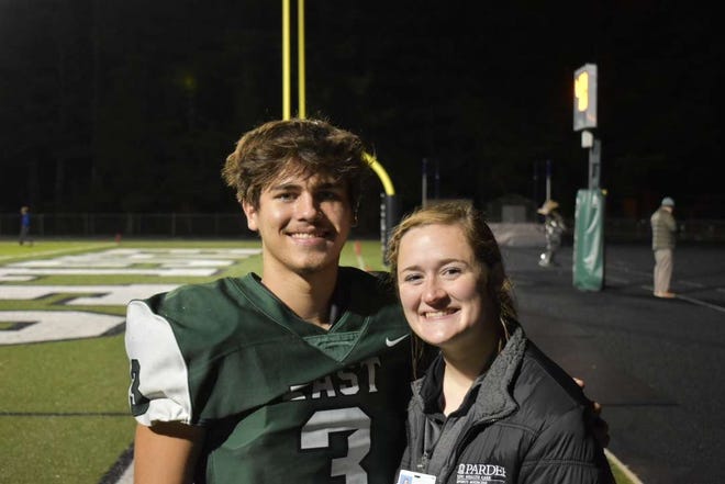 East Henderson quarterback Joseph Justice, left, poses with athletic trainer Sarah Warren before a game earlier this season at East.