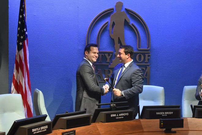 Outgoing Sarasota Mayor Hagen Brody (right) shakes hands with commissioner Erik Arroyo right after the City Commission voted to make Arroyo the new mayor.