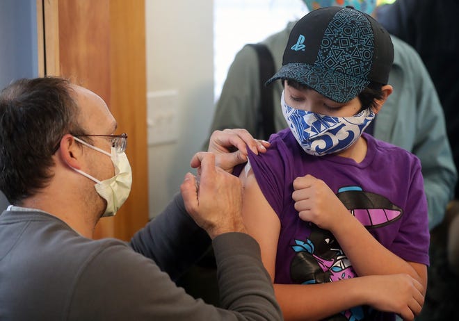 Dr. Kristan Guenterberg administers a COVID-19 vaccination to student Ben Imazeki-Miyahara, 11, at Silverwood School in Central Kitsap on Thursday, Nov. 4, 2021.
