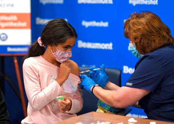 Alexa Ghorayeb, 10, menerima vaksin Pfizer dari perawat Theresa Clancy di Beaumont Hospital Service Center di Southfield pada Jumat, 5 November 2021.