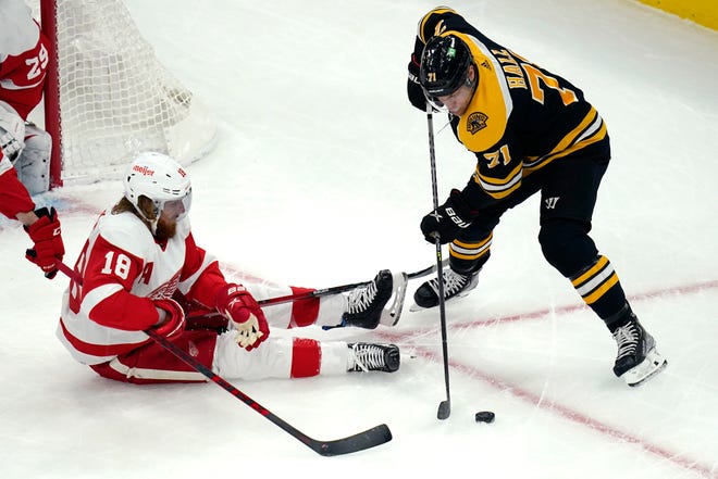 Pemain bertahan Detroit Red Wings Marc Staal, duduk, dan sayap kiri Boston Bruins Taylor Hall (71) bersaing untuk mendapatkan keping selama periode pertama pertandingan hoki NHL Kamis, 4 November 2021, di Boston.