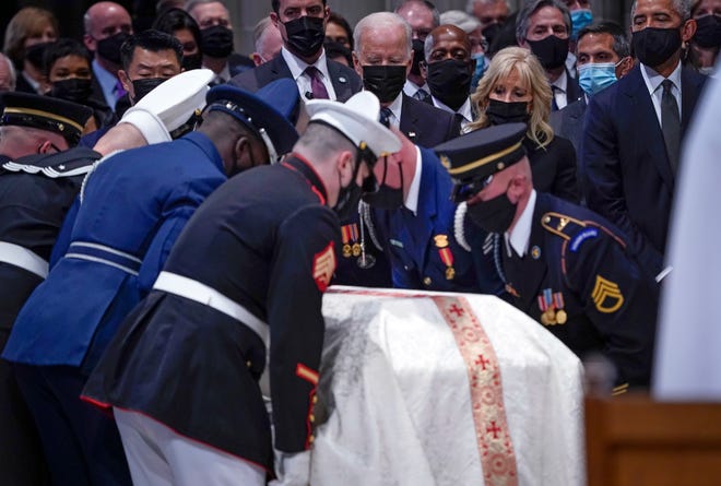 President Joe Biden and First Lady Jill Biden and former President Barack Obama, right, watch Colin Powell's casket arrive at the Washington National Cathedral.  Powell is remembered for a lifetime of public service at a funeral at the Washington National Cathedral.