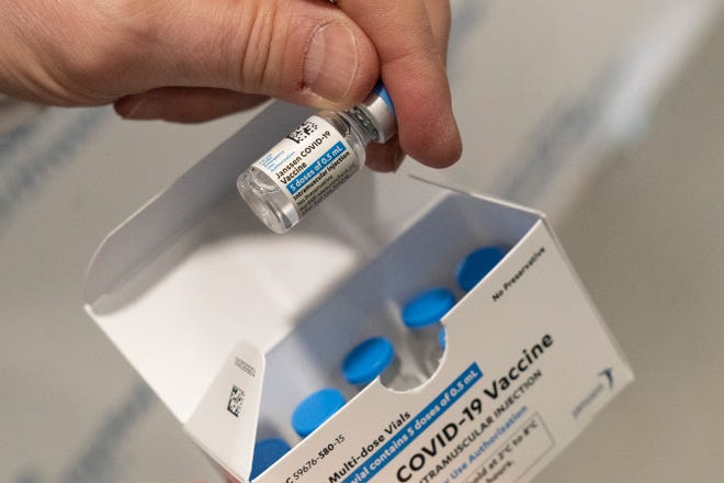 A pharmacist holds a vial of the Johnson & Johnson COVID-19 vaccine at a hospital in Bay Shore, New York
