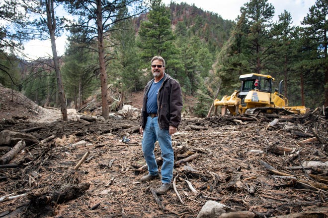 Dan Bond stands in a debris field on Nov. 3, 2021. The debris was left over from the Black Hollow post-fire debris flow near his Colorado home.