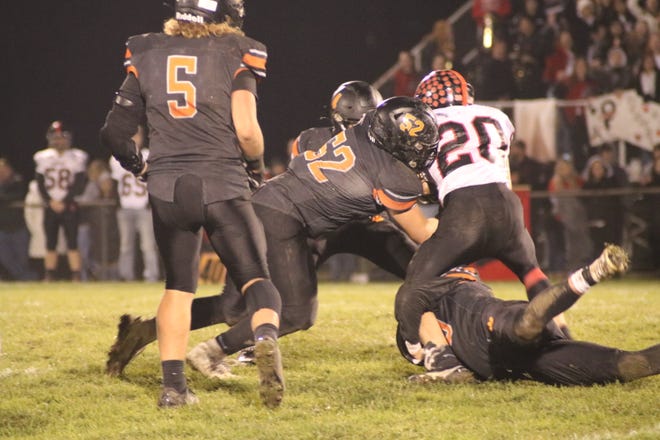 Hudson's Logan Sallows (52), Austin Marry (4) and Logan Ryan, right, wrap up Addison's Ryan Worsham during the first half of Friday night's Division 8 district final game at Thompson Field in Hudson.