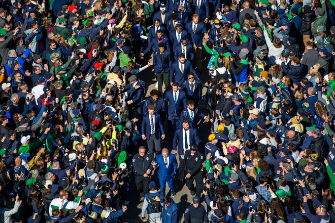 Notre Dame players on the Player Walk to the stadium are greeted by fans before the Notre Dame-Navy football game, Saturday, Nov. 6, 2021, at Notre Dame Stadium in South Bend.